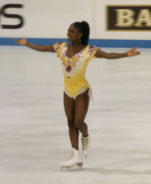 Photo de Surya Bonaly en robe jaune sur la glace.