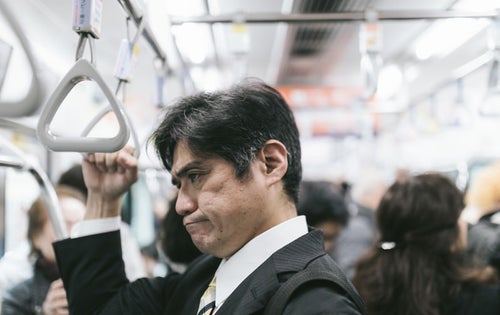 電車内の迷惑行為を見て思わずイラッとくる中年の男性の写真