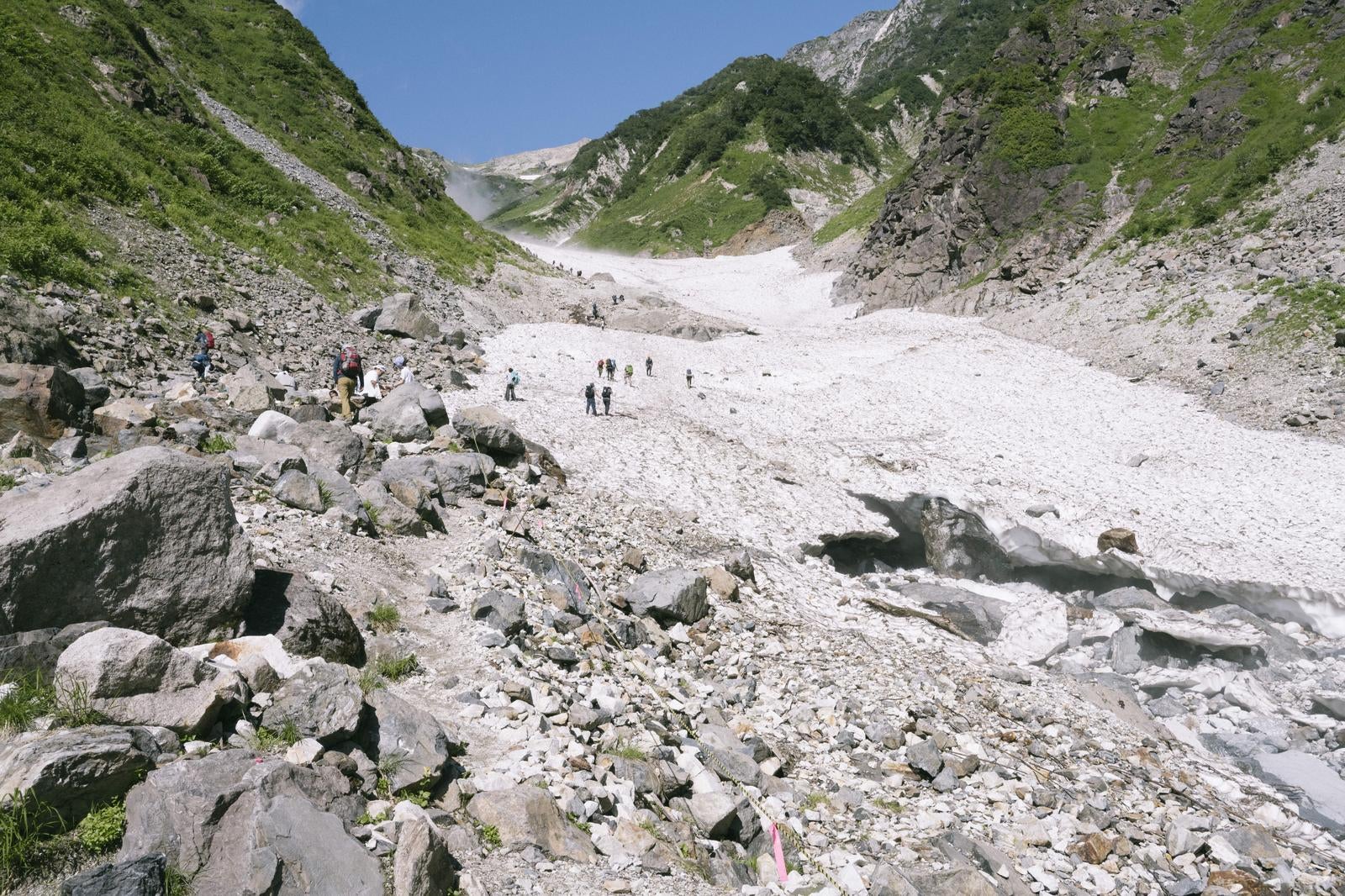 「崩落した白馬尻から複数の登山者が歩む風景」の写真