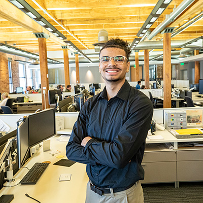 UWM student standing inside architectural firm with arms crossed