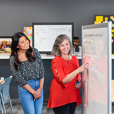 UWM student standing next to her mentor at whiteboard