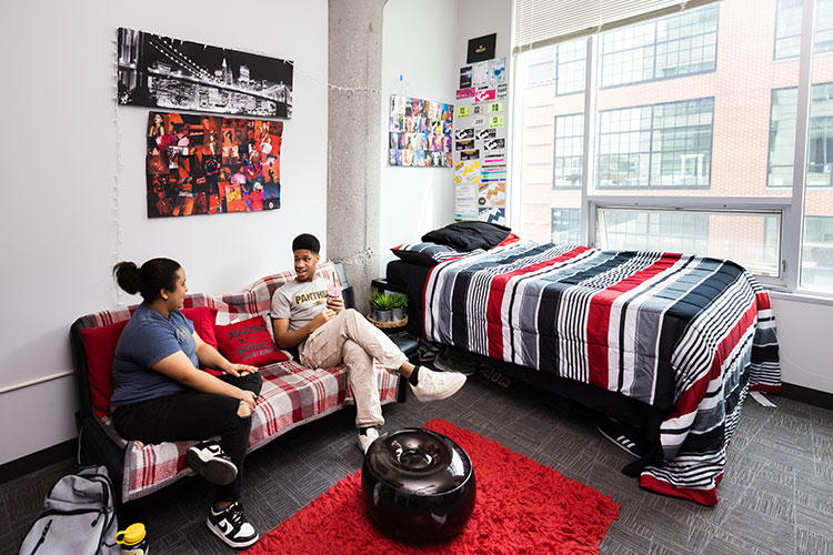 Two students sit in Kenilworth Square dorm room