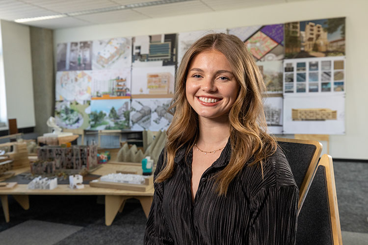 Architecture student Madison smiling and sitting in architecture studio