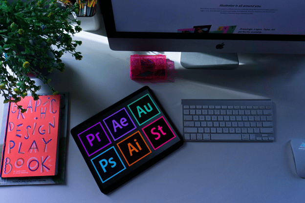 keyboard and tablet on a table displaying the different adobe application icons