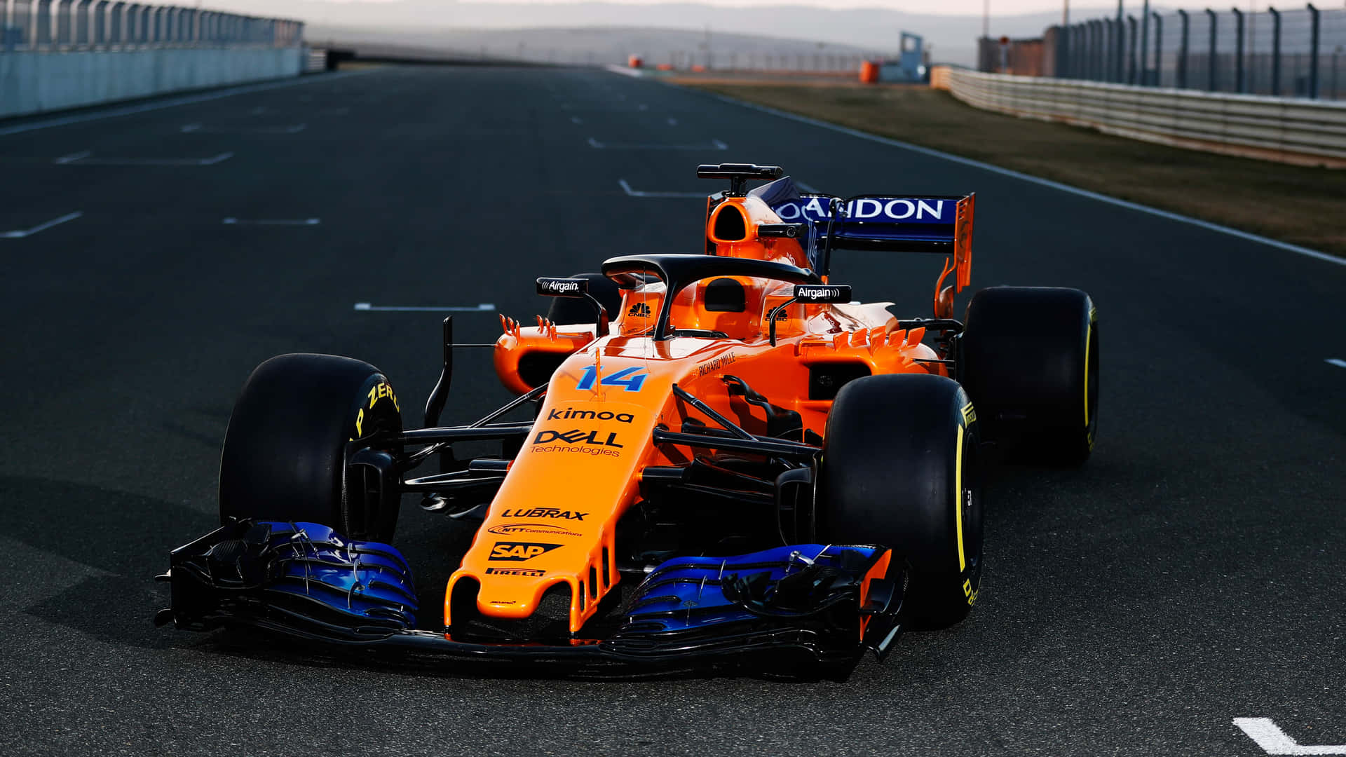 Uncoche De Carreras Naranja Está Conduciendo Por Una Pista. Fondo de pantalla