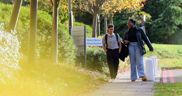 Two students walking by the medical school