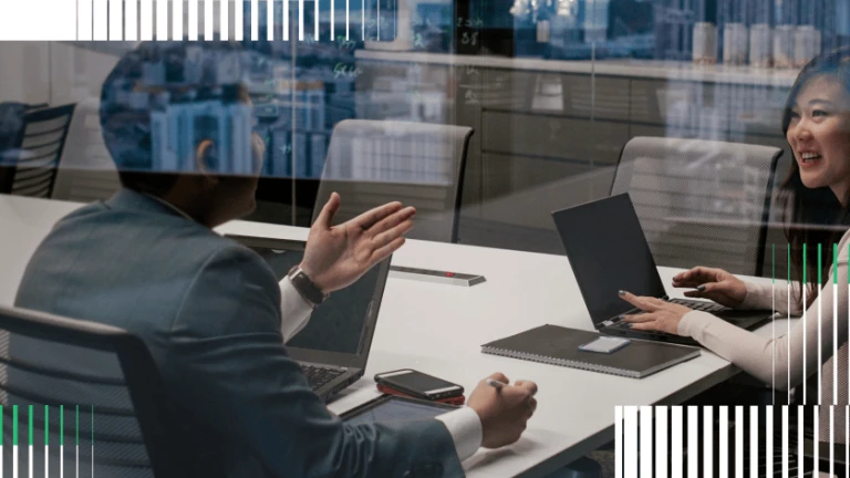 Two People Sitting at a Conference Table Talking with Eachother