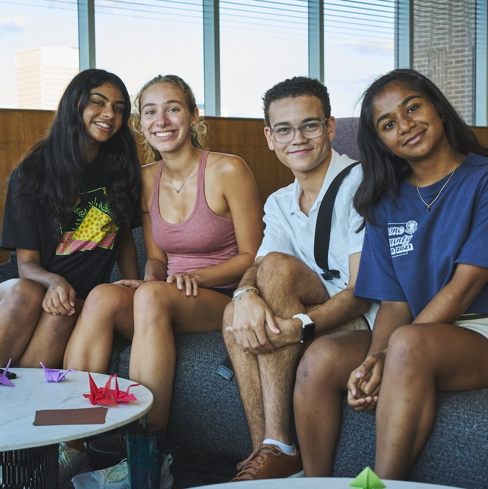 Four students sitting beside each other on couch