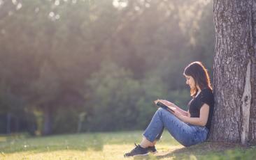 Girl reading a book outside