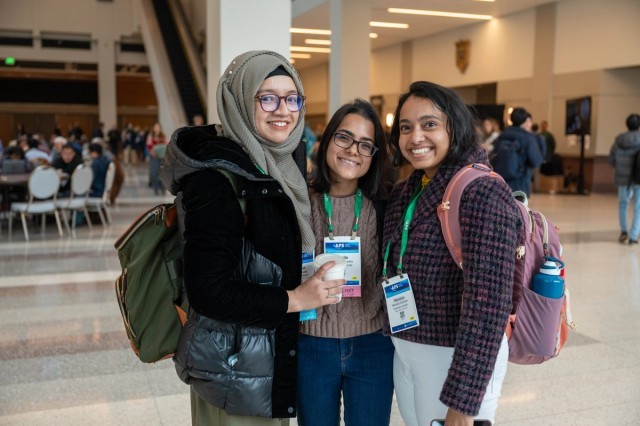 Three APS members pose for a group photo at a conference.