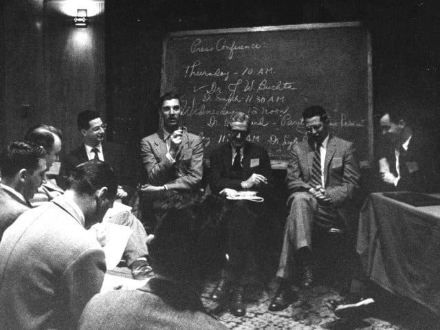 Midcentury photograph of men seated in a circle