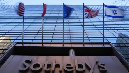 A skyscraper with flags and a sign reading Sotheby's.