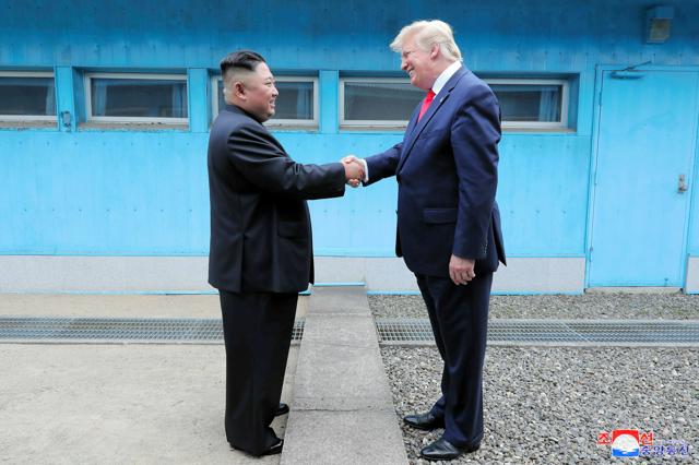 2019年6月30日、板門店で握手する北朝鮮の金正恩総書記（左）と米国のトランプ大統領（当時）。朝鮮中央通信が配信した=ロイター