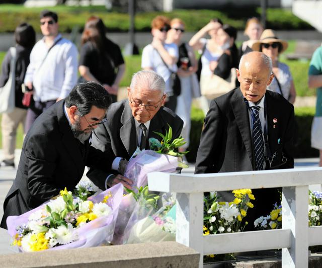 原爆死没者慰霊碑にノーベル平和賞受賞の決定を報告し、献花する箕牧智之理事長（右）ら広島県被団協のメンバー=2024年10月13日午前9時59分、広島市中区の平和記念公園、上田潤撮影