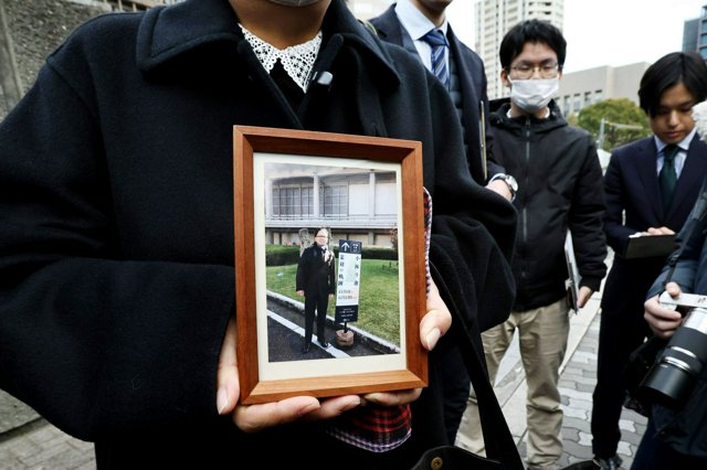 判決後、赤木俊夫さんの遺影を持って大阪高裁前で記者の取材に応じる妻の雅子さん=2025年1月30日午後2時46分、大阪市北区、水野義則撮影