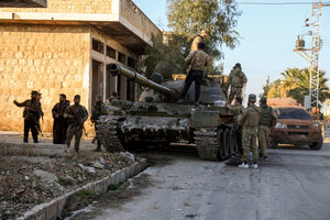 シリアのアレッポの南西に位置するマアッラト・ヌウマーンの町で2024年11月30日、シリア軍の戦車の上に立つ反体制派の戦闘員ら=AP