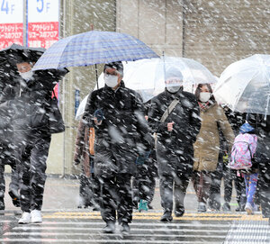 雪が降る中、通勤する人たち=2025年1月10日午前8時、名古屋市中村区、溝脇正撮影