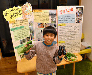 庭で育てた野菜を持つ浜本隆善さん。一連の出来事を夏休みの自由研究としてまとめた=2024年11月26日、大阪府箕面市、田中祐也撮影