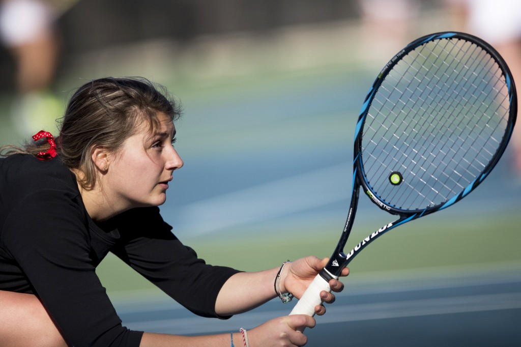 Bates student ready to hit the ball during a tennis match.