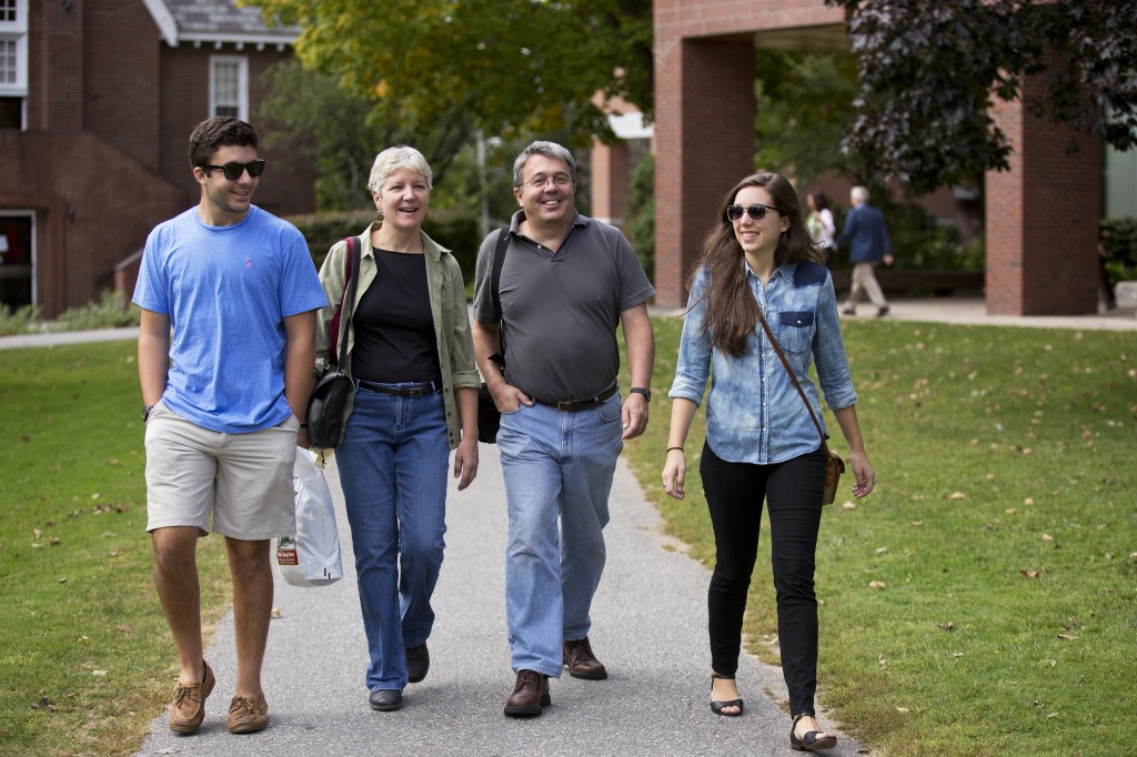 Four people walking along the path at the Library quad.