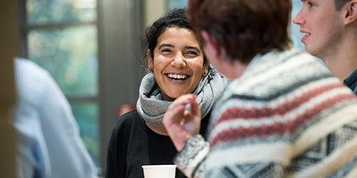 A female student laughing with two other colleagues.