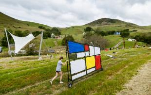 A student wheels a project into the 2024 Design Village