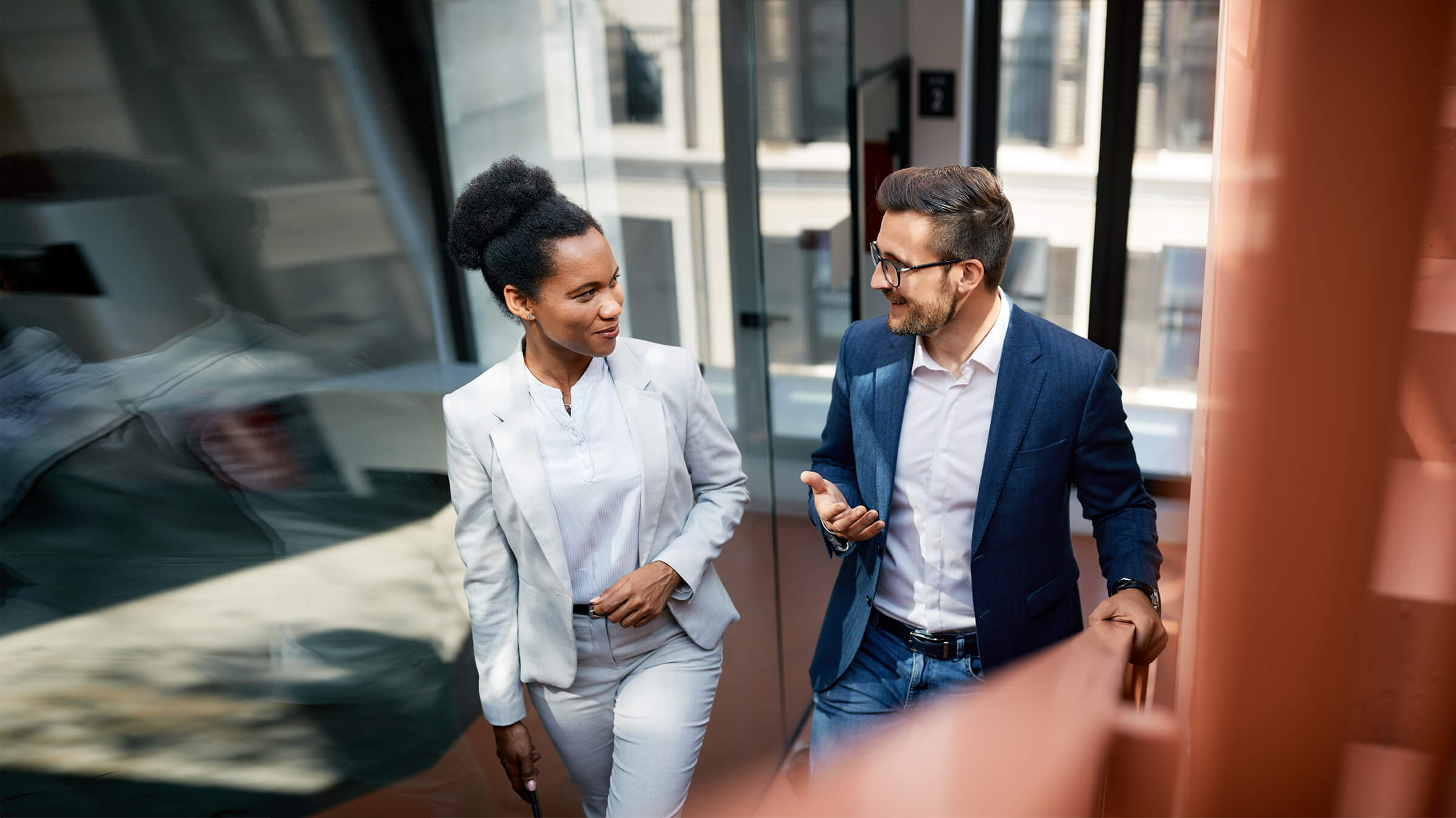 Two people walking through office