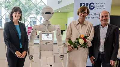 Prof. Angela Schoellig von der Technischen Universität München (links), Bundesforschungsministerin Bettina Stark-Watzinger (Mitte) mit Prof. Tamim Asfour vom Karlsruher Institut für Technologie bei der Vorstellung des RIG in Berlin. Mit dabei: Roboter ARMAR-7 aus dem KIT.  (Foto: BMBF)