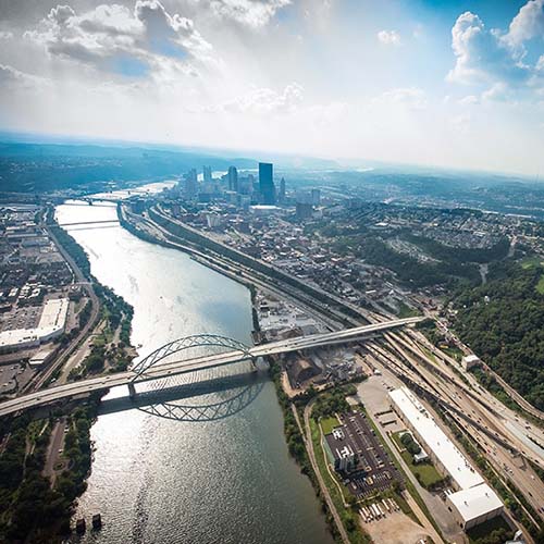 A photo of Pittsburgh in the background with images of CMU students and faculty in the foreground.