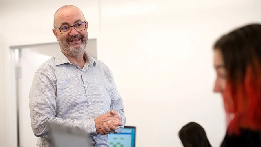 professor standing in classroom across from student