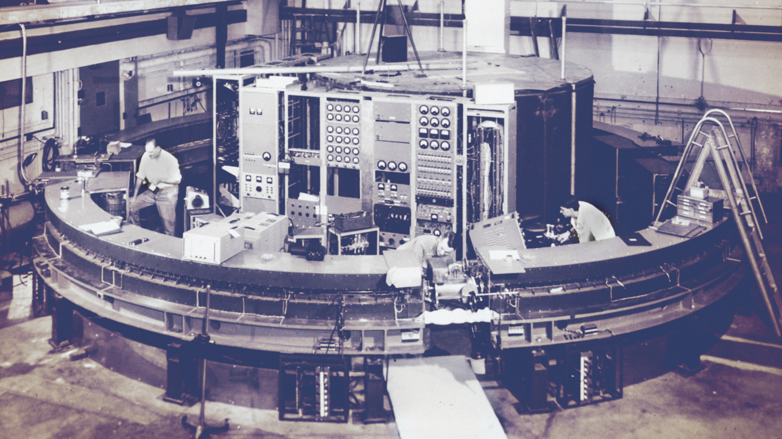 Three men working in a circular lab..