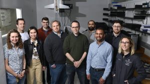 A team of Hopkins researchers pose in a lab.