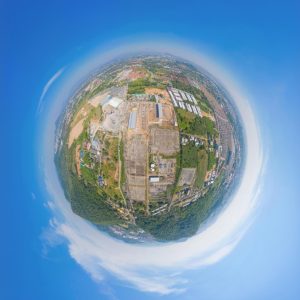 Illustration of the Earth in a bright blue sky, with images of man-made construction on the surface.