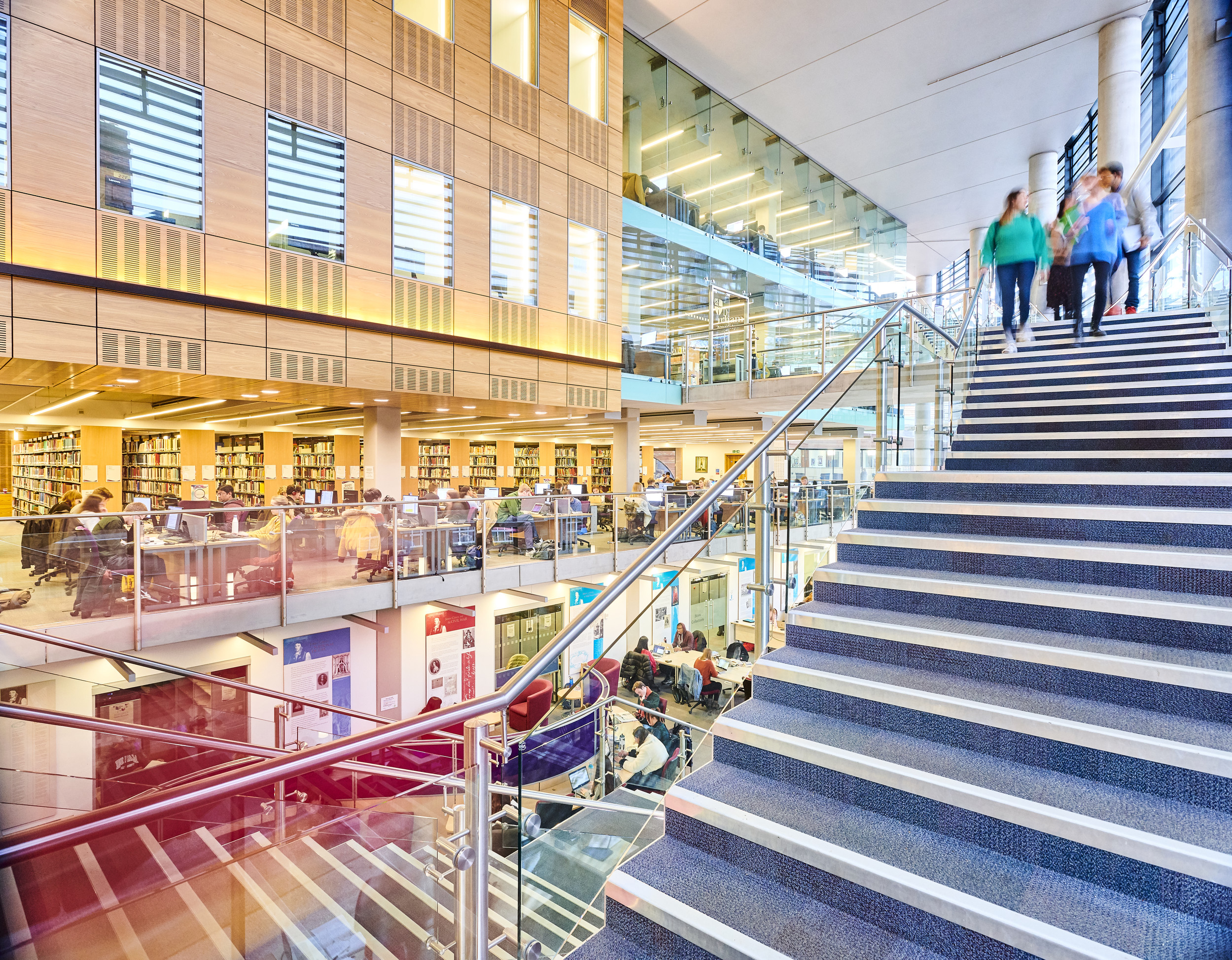 Students walking down the staircase into the library