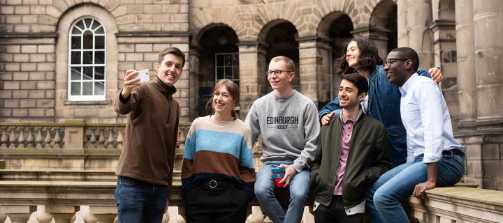 A group of students in Old College Quad taking a selfie