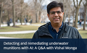 Vishal Monga smiles at the camera while standing outside