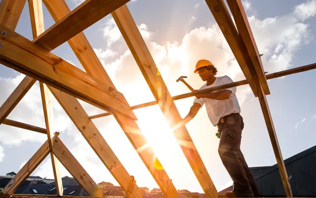 construction worker hammering roof truss