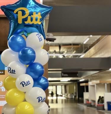 Blue, gold, and white balloons decorate Posvar Hall 