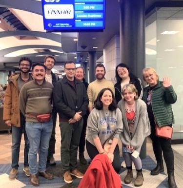 Group of students pose for a photo at the airport