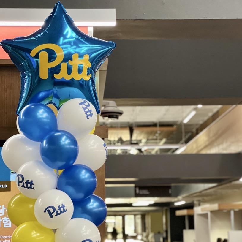 Blue, gold, and white balloons decorate Posvar Hall 