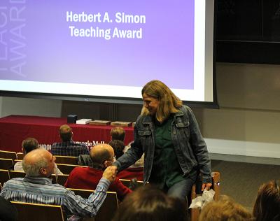 Brad Myers shakes Raelin Musuraca's hand as she walks back to her seat after winning an award