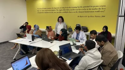 researchers seated at a table examining GBD Compare data visualization on their laptops