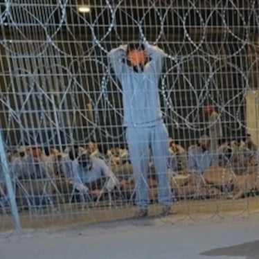 A leaked photograph of the detention facility at the Sde Teiman military base shows a blindfolded man with his arms above his head. Interviewed healthcare workers described this image as punishment imposed by Israeli soldiers on Palestinian detainees if they speak or move. 