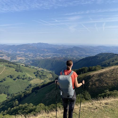 Frau mit Rucksack vor Gebirgslandschaft in Spanien