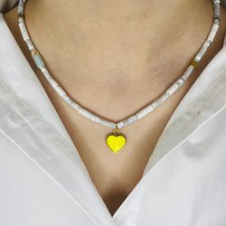 grey necklace with a yellow heart pendant