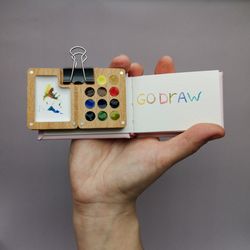 mini wooden watercolor palette, with small sketchbook.