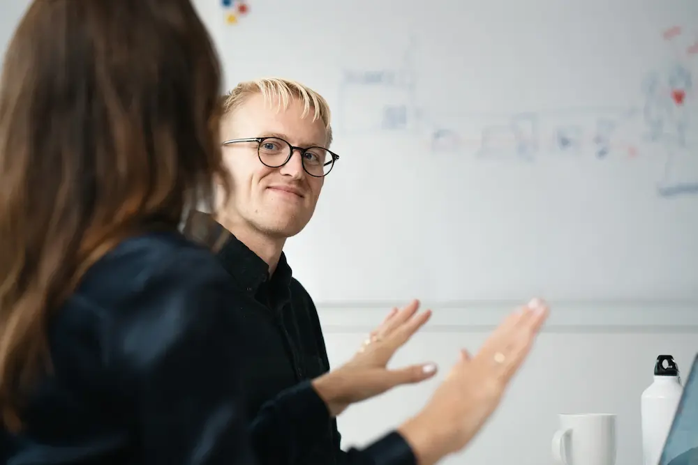 Colleagues discussing in front of a whiteboard