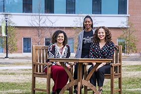 Three female APLers sitting together outside