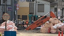 湧き出る水が作業妨げ　道路陥没、運転…