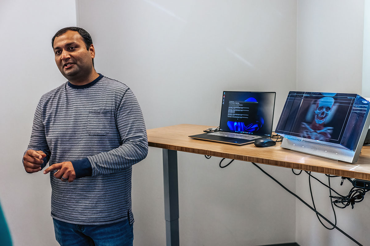 Kitware employee standing in front of laptops